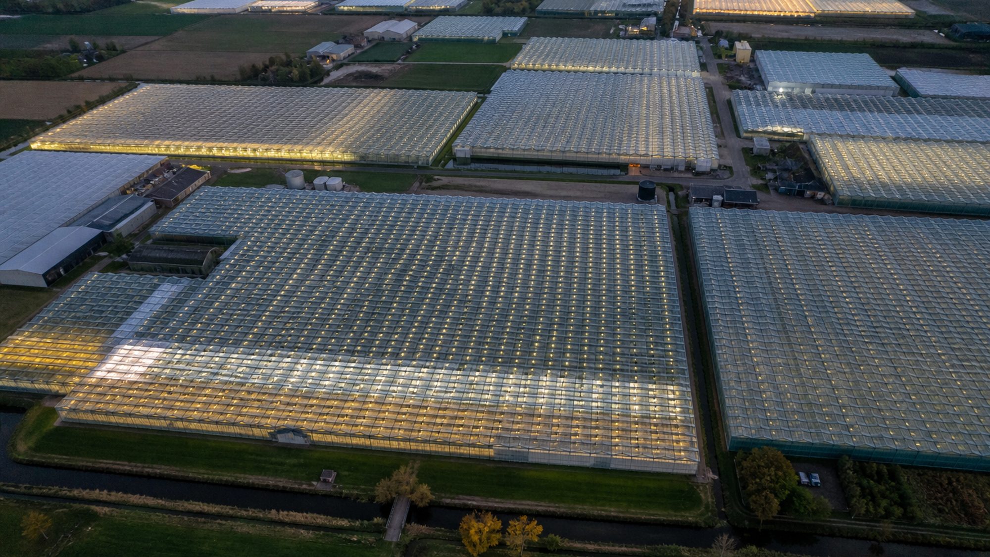 Kassencomplex in de schemering van bovenaf, daken licht oplichtend